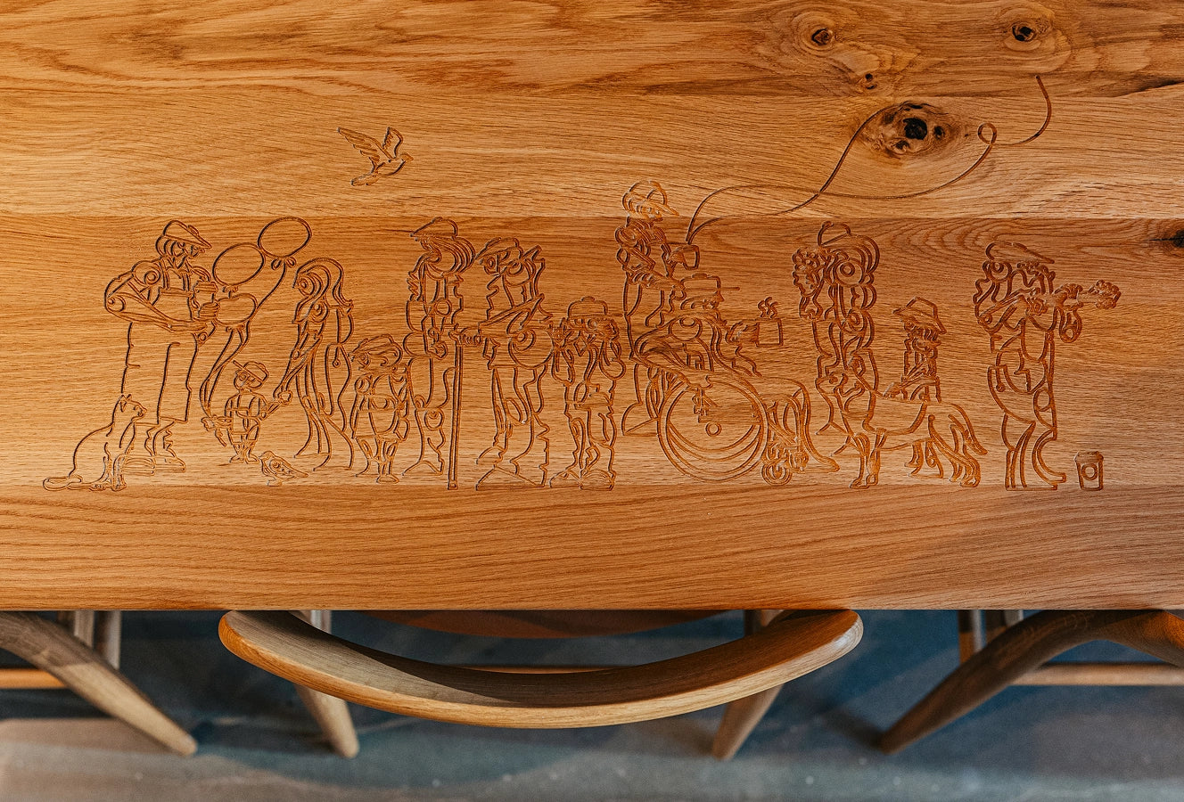 Wooden table at a Starbucks coffeehouse, with intricate carvings of people and animal figures on the surface.