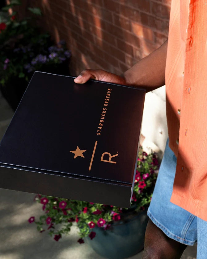 Person holding a Starbucks Reserve coffee box with a blurred background