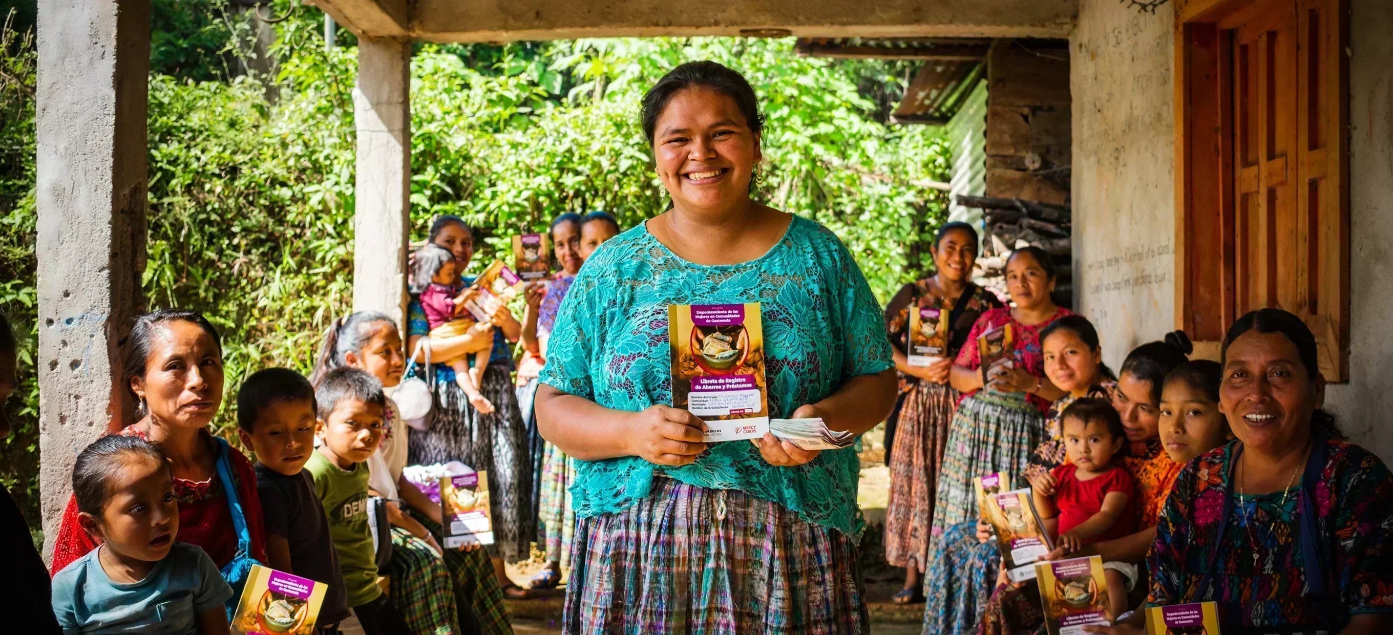 Woman holding a package in front of a group of people outdoors