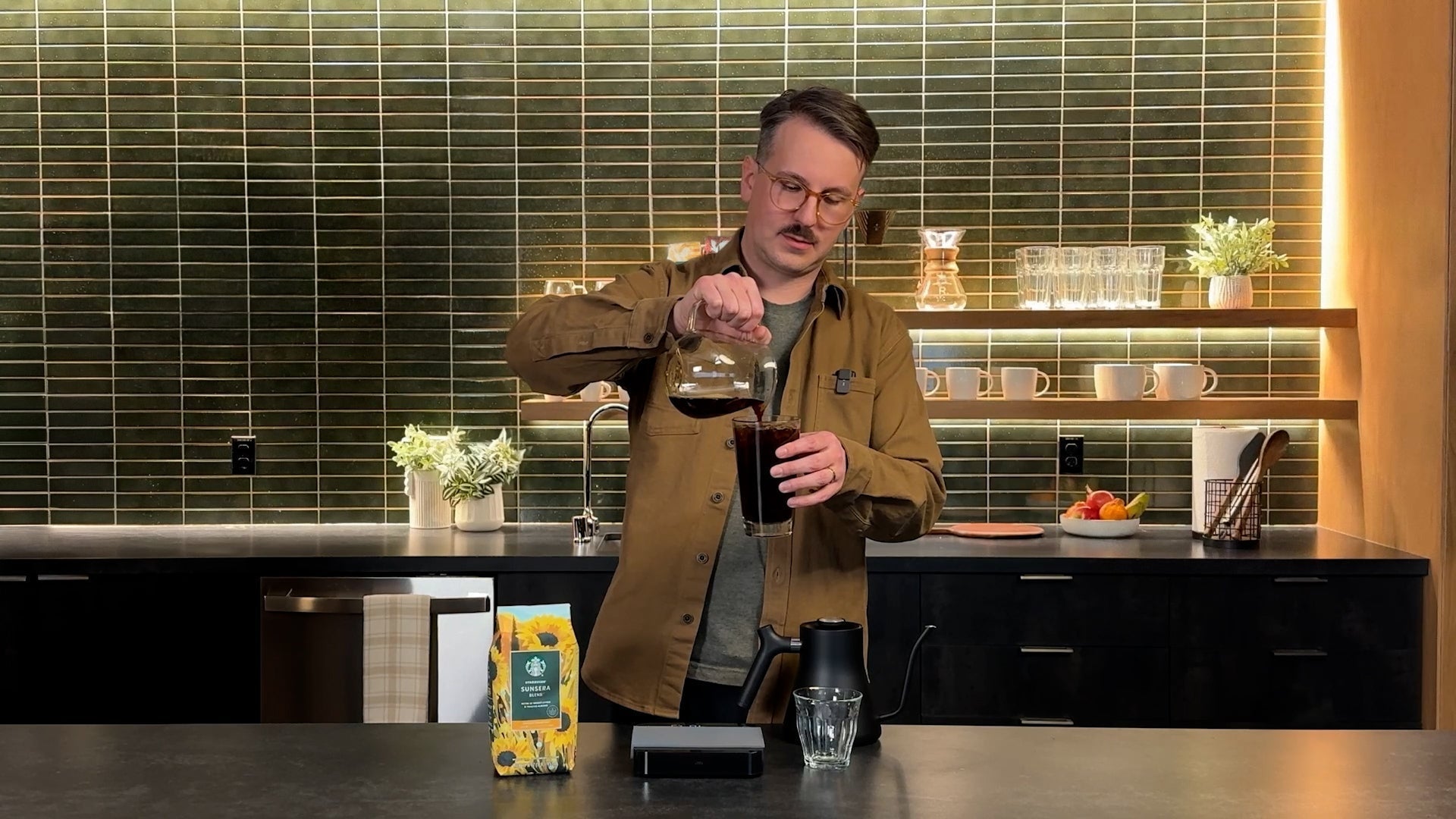 Coffee Expert, Lincoln making a cold pour, where he is pouring the coffee from a jug into a glass in a kitchen setting.