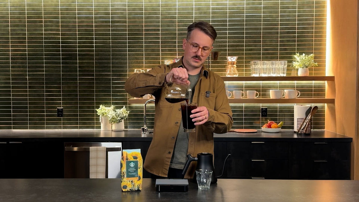 Coffee Expert, Lincoln making a cold pour, where he is pouring the coffee from a jug into a glass in a kitchen setting.