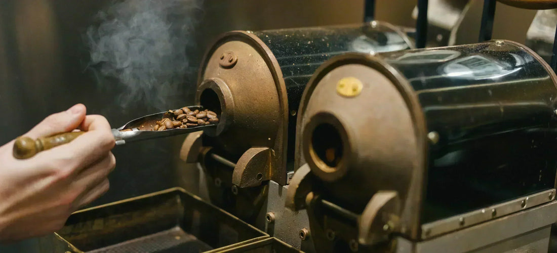 Person loading coffee beans into a coffee roaster.
