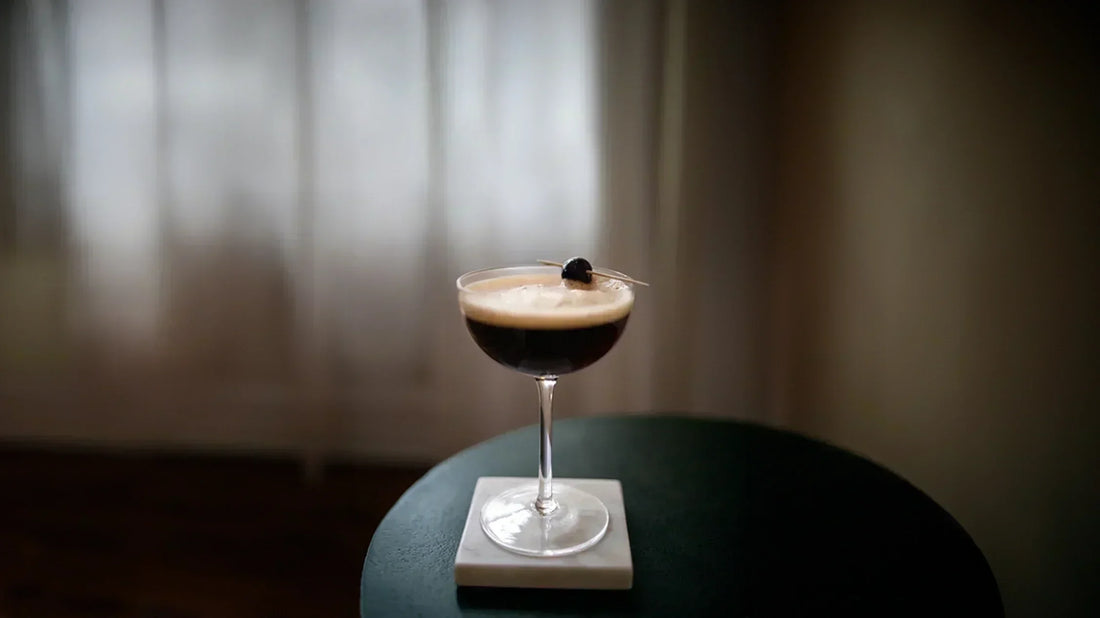 Cocktail in a glass with a dark liquid on a blurred background