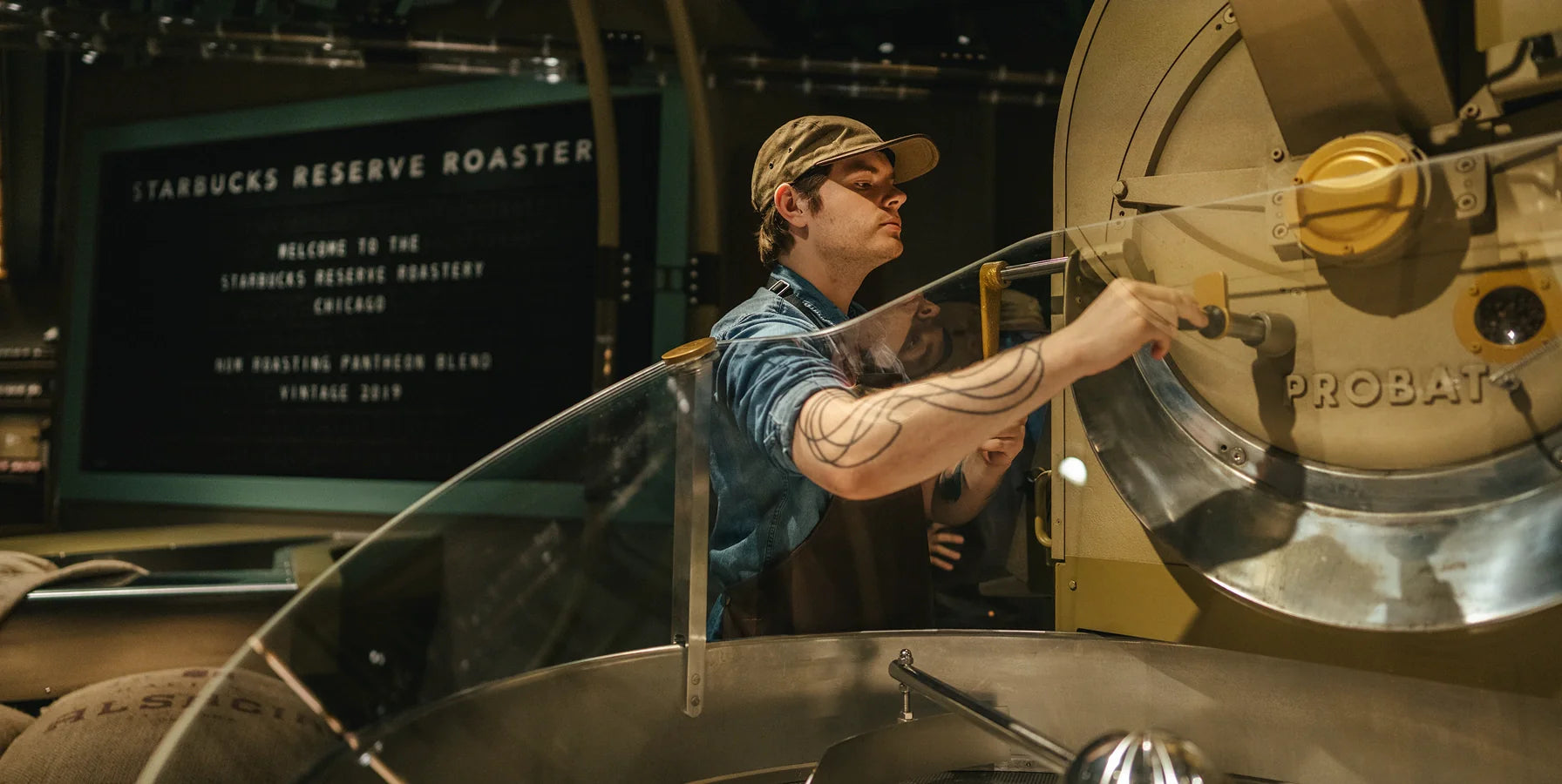 A person operating a coffee roasting machine at Starbucks Reserve Roastery.