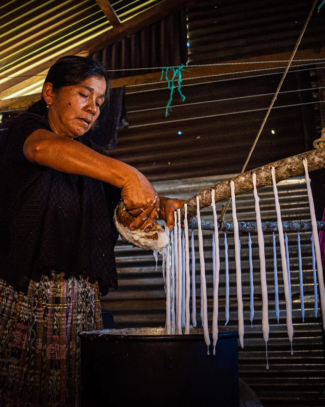 Woman melting wax to create candles.