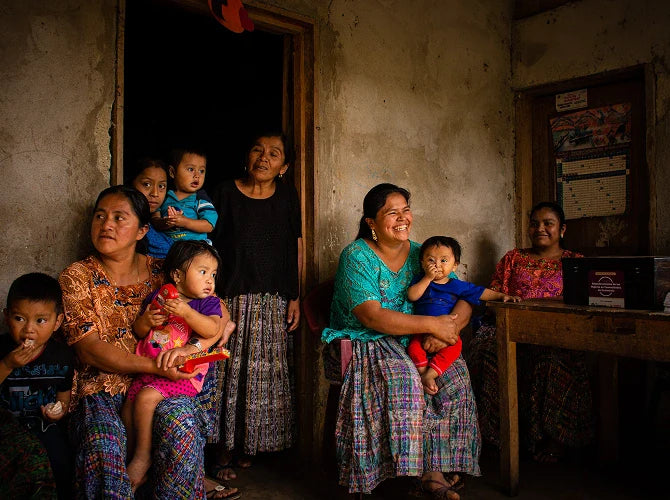 A group of women and children sitting together in a room.