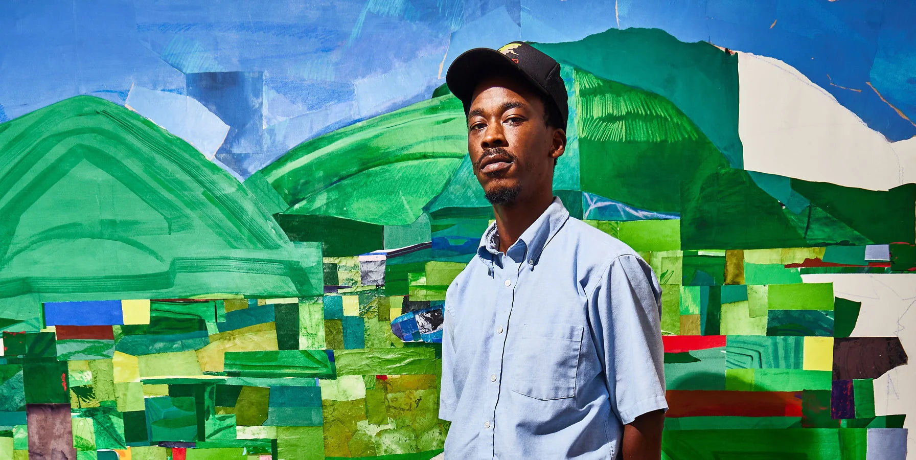 The artist, Hampton Boyer, standing in front of his colourful abstract artwork.
