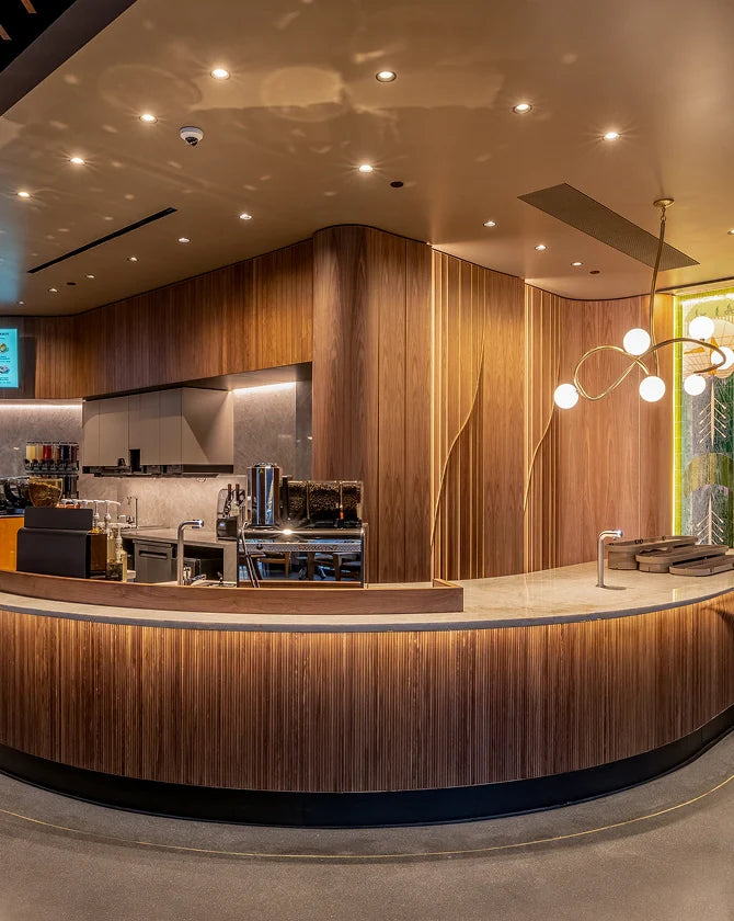 Interior of a Starbucks coffeehouse, with wooden textures, marble countertops and decorative wall art by local artists.