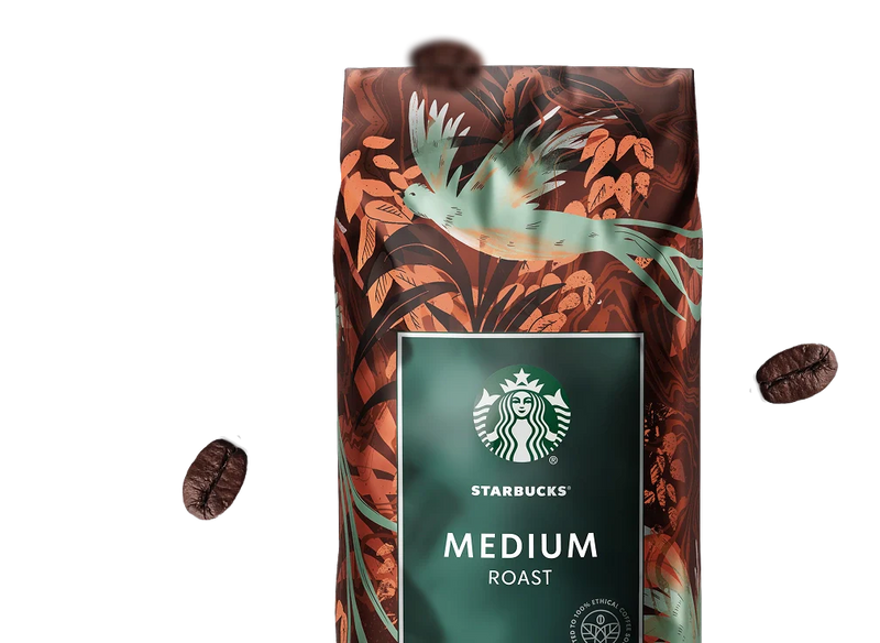 Starbucks Medium Roast coffee bag with decorative design and floating coffee beans against the background.