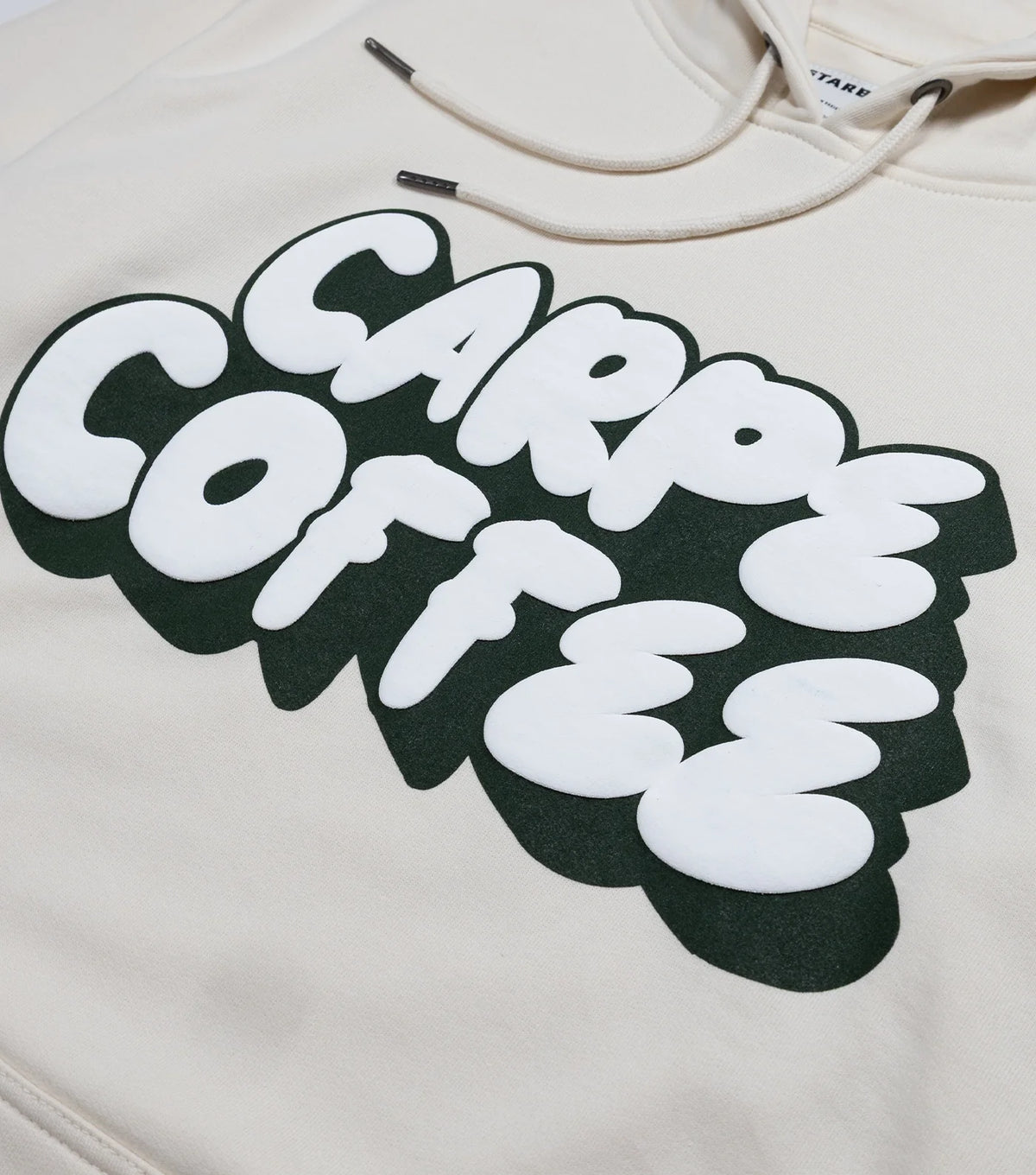 Close up of a bold white text design that says Carpe Coffee across the chest of the Starbucks Carpe Coffee Hoodie.