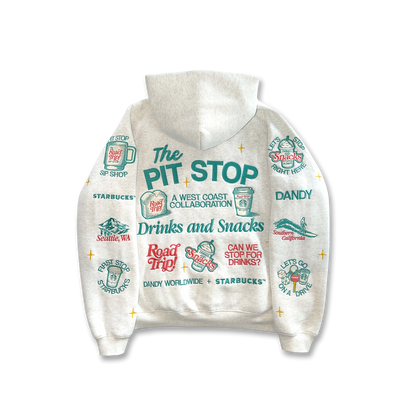 A white hooded sweatshirt featuring a colorful graphic print with 'The PIT STOP' text and various Starbucks and Dandy logos and illustrations, shown against a plain white background.