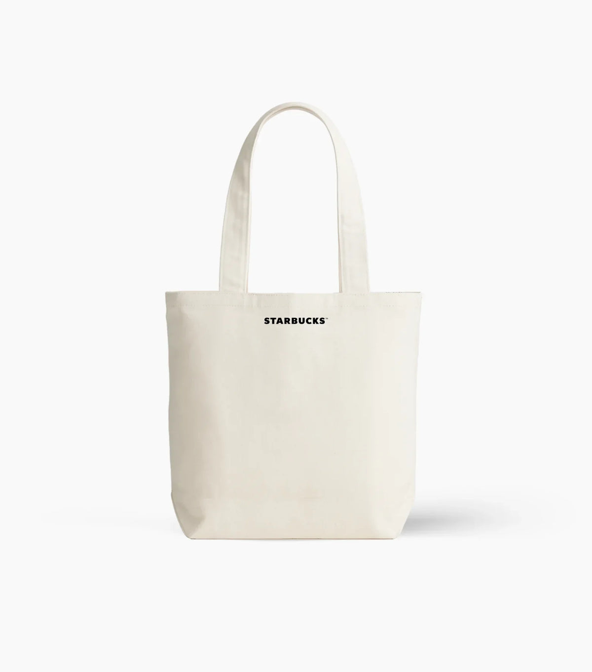 An off-white canvas tote bag with black 'STARBUCKS' text printed on the front, set against a plain white background.