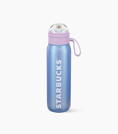 A periwinkle water bottle with the Starbucks name down the side and a lilac lid topped with a small snow globe holding a Bearista bear, shown on a clean white background.