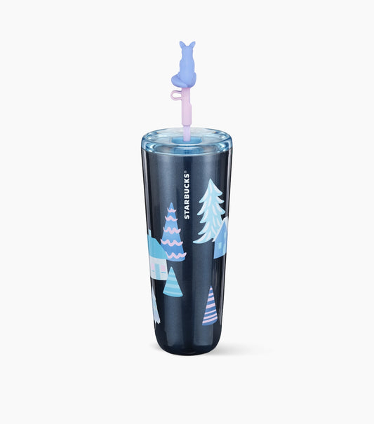 A dark navy blue Starbucks travel tumbler with a winter-themed illustration of houses and pine trees in shades of blue and white. The tumbler is shown with a clear lid and a straw topped with a light purple fox-shaped straw topper.
