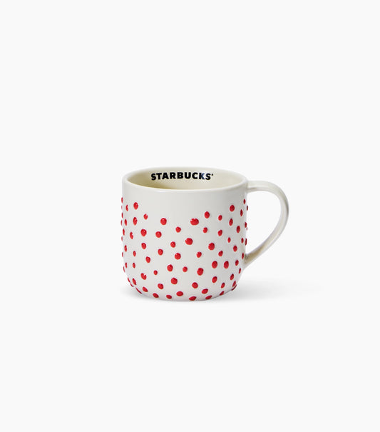 A white ceramic Starbucks coffee mug with a pattern of small red polka dots and the black 'STARBUCKS' logo printed inside the rim, set against a clean white background.