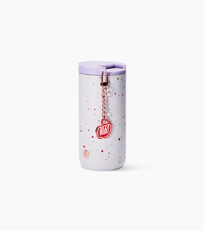 A light lavender travel tumbler with red speckles, a matching lavender lid, and a rose gold chain charm featuring a red 'PSL' design, set against a plain white background.