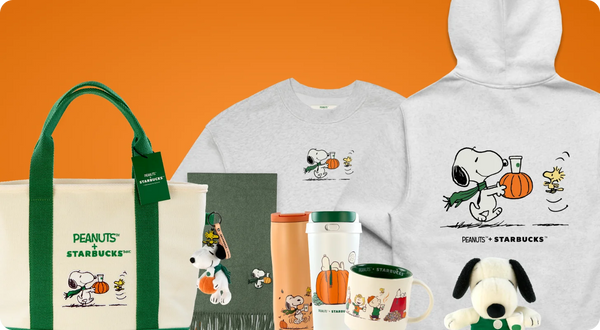 A collection of Peanuts x Starbucks merchandise displayed against a solid orange background, including a canvas tote bag, a light gray crewneck t-shirt, a matching hoodie, travel tumblers, a mug, and a plush dog toy.