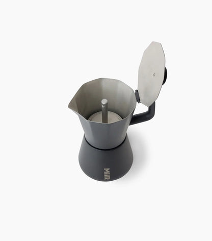 Black Miir Moka Pot Espresso Maker with lid opened, showing the inside of the top chamber, against a white background.