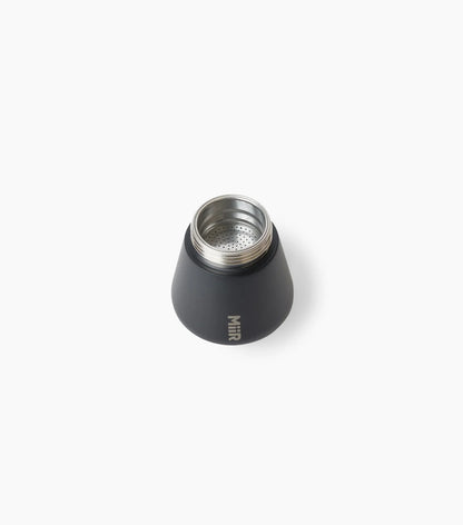 Filter basket of a black Miir Moka Pot Espresso Maker, sitting on top of the bottom chamber, against a white background.