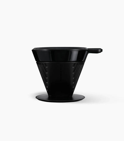 Black plastic Starbucks Pour-Over Brewer with handle towards the right, on a white background.