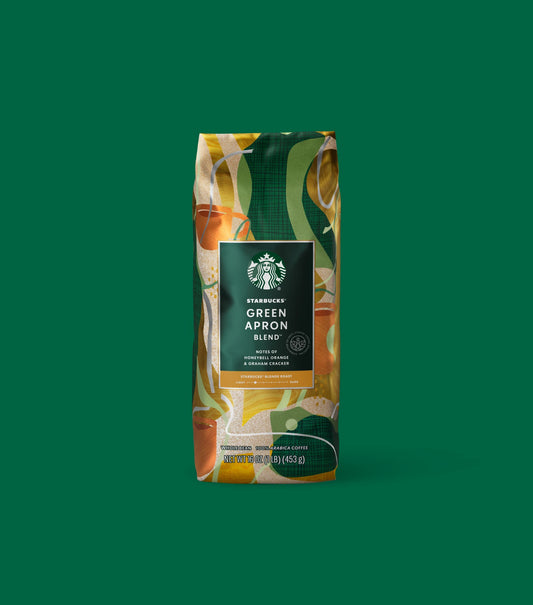 Starbucks Green Apron Blend coffee bag on a green background.