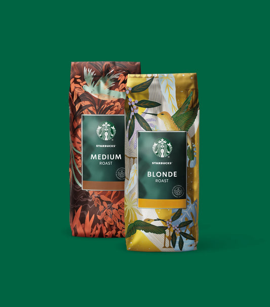 Two coffee bags from the Starbucks Coffeehouse Selections subscription - the one on the left is labeled Medium Roast and on the right, Blonde Roast, both on a green background.
