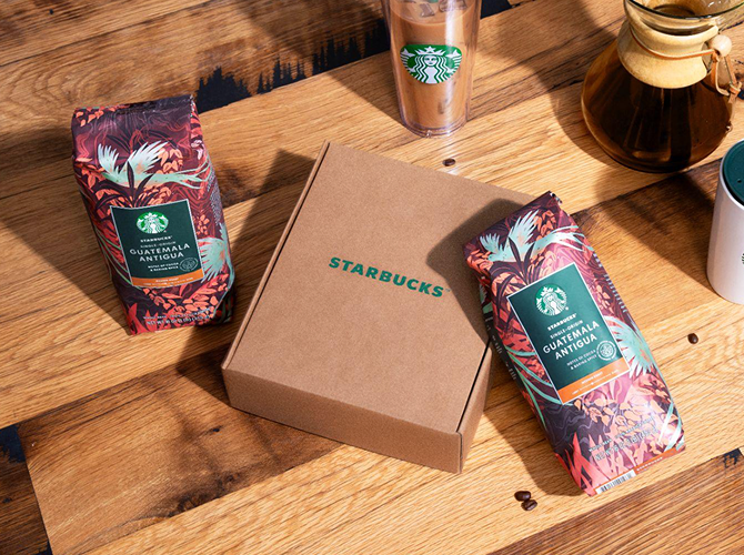 Starbucks subscription box with two bags of Starbucks Single-Origin Guatemala Antigua coffee on a wooden surface.