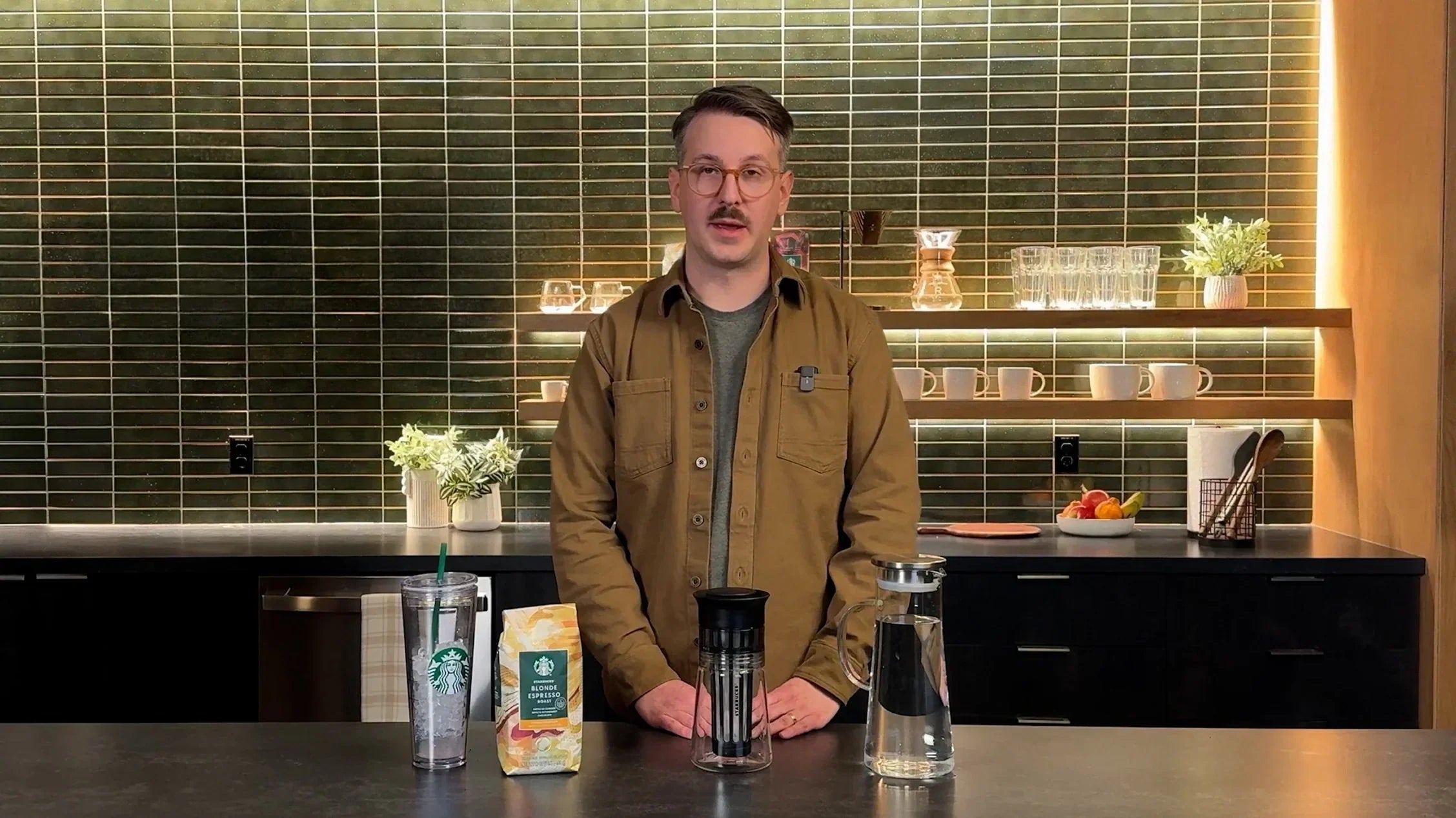 Person standing in a kitchen with coffee-making equipment and ingredients.